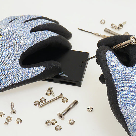 The Level 5 Cut Resistant Gloves Cru553 in Blue being used in a task requiring precision, showing its great grip, comfort, and flexibility.