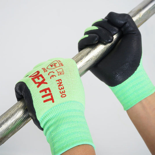 The Nitrile-Coated Work Gloves FN330 in Green worn while grabbing a textured steel pipe which showcases its excellent grip on any surface.