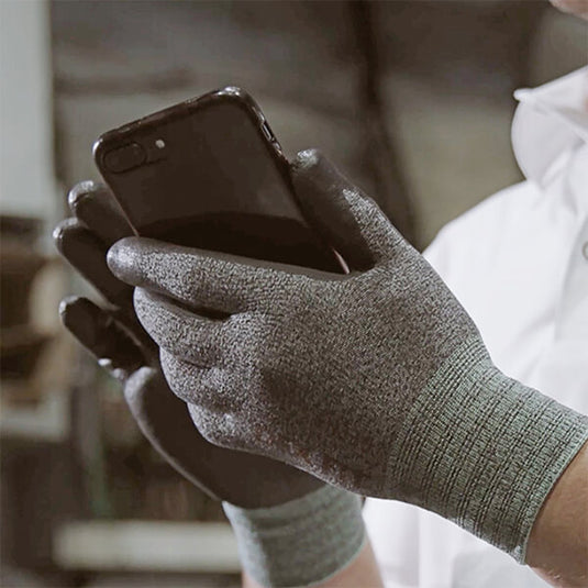 Wearing the Level 2 Cut Resistant Gloves CR533 while using a touchscreen smartphone.